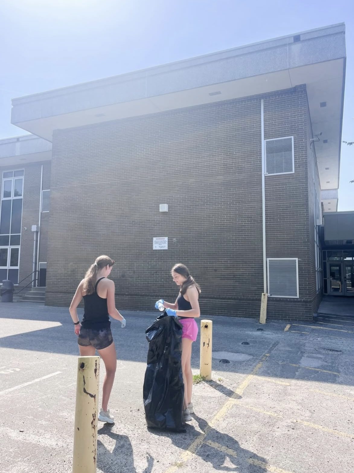 Two Hoggard IB students picking up litter around campus